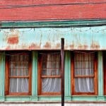 Weathered commercial storefront with faded and peeling paint showing signs that commercial painting in Baton Rouge is overdue.