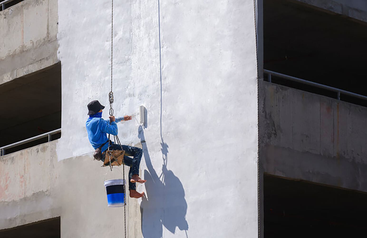 Professional painter applying paint to a commercial building exterior in Baton Rouge