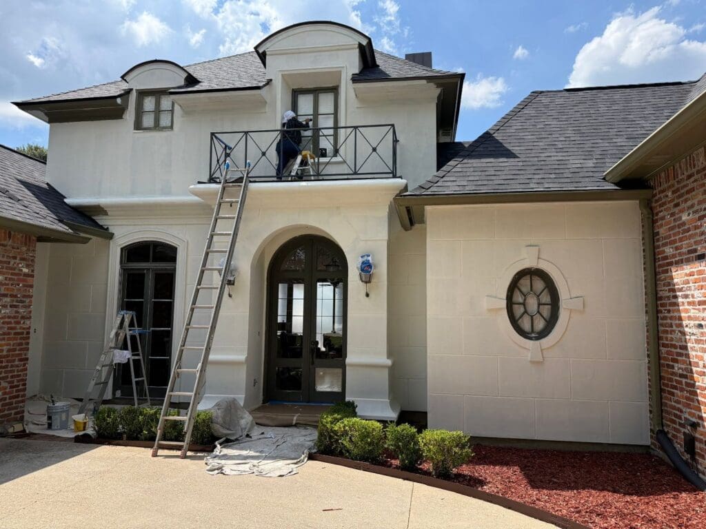 Crew painting front balcony from ladder on St. George exterior painting job
