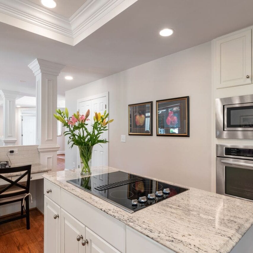 Kitchen cabinet painters in Baton Rouge LA created this two tone kitchen with white uppers and a dark island