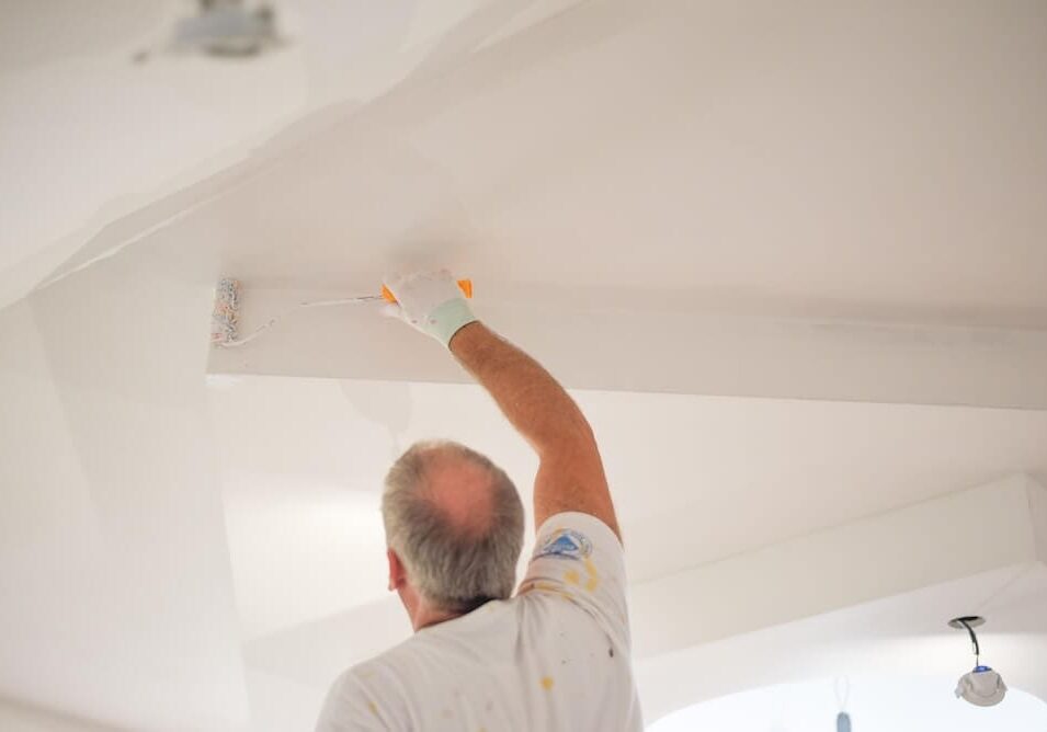 Professional painter applying paint to a ceiling during an interior painting project